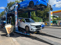 A 2024 Honda CR-V in Platinum White Pearl drives off the transporter
