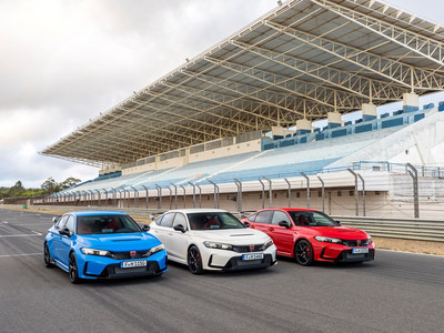 A trio of Civic Type R's in blue, white and red sit on a race track